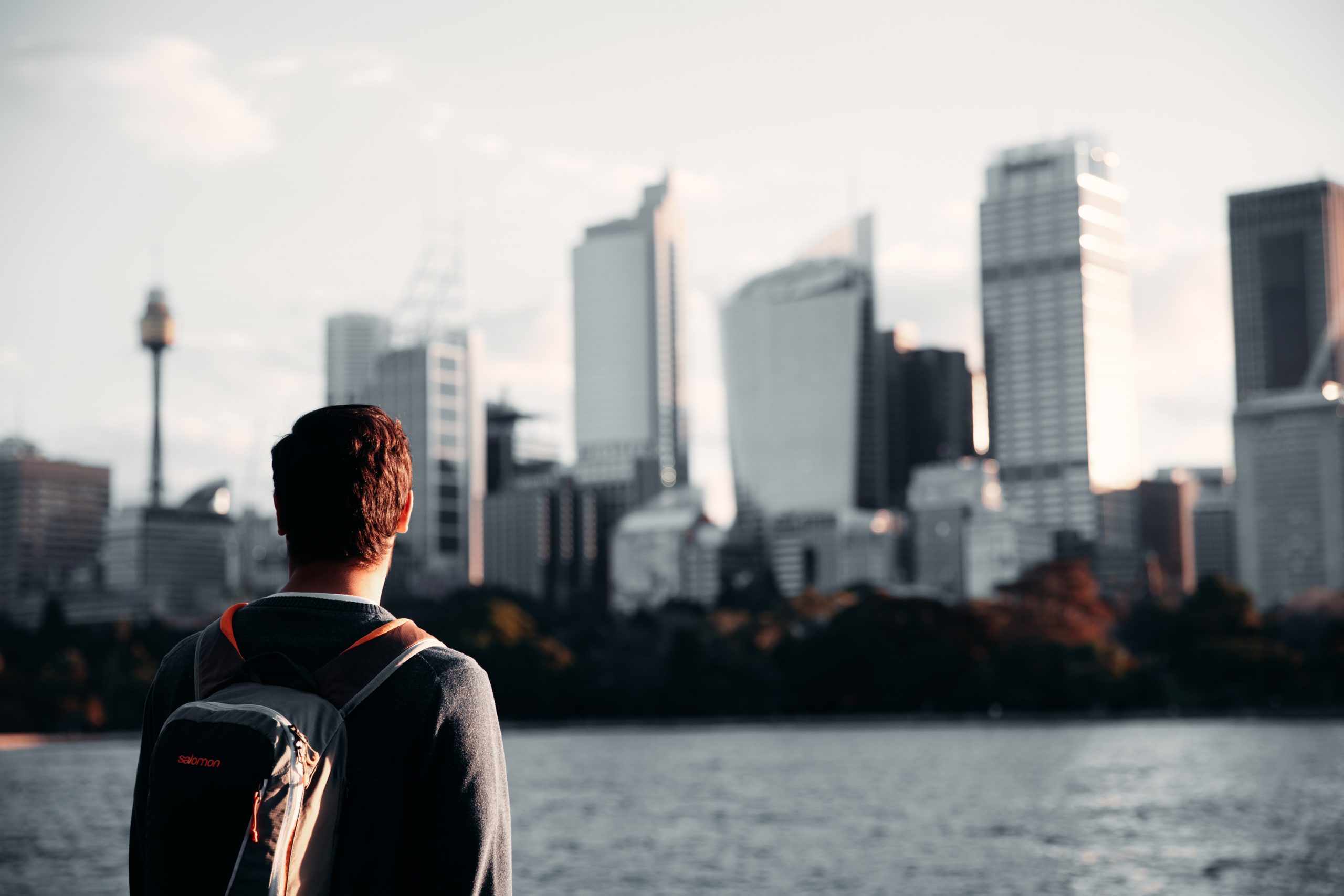 man in front of Sydney city building skyline at sunset at Mrs Macquarie's Chair (The Domain)