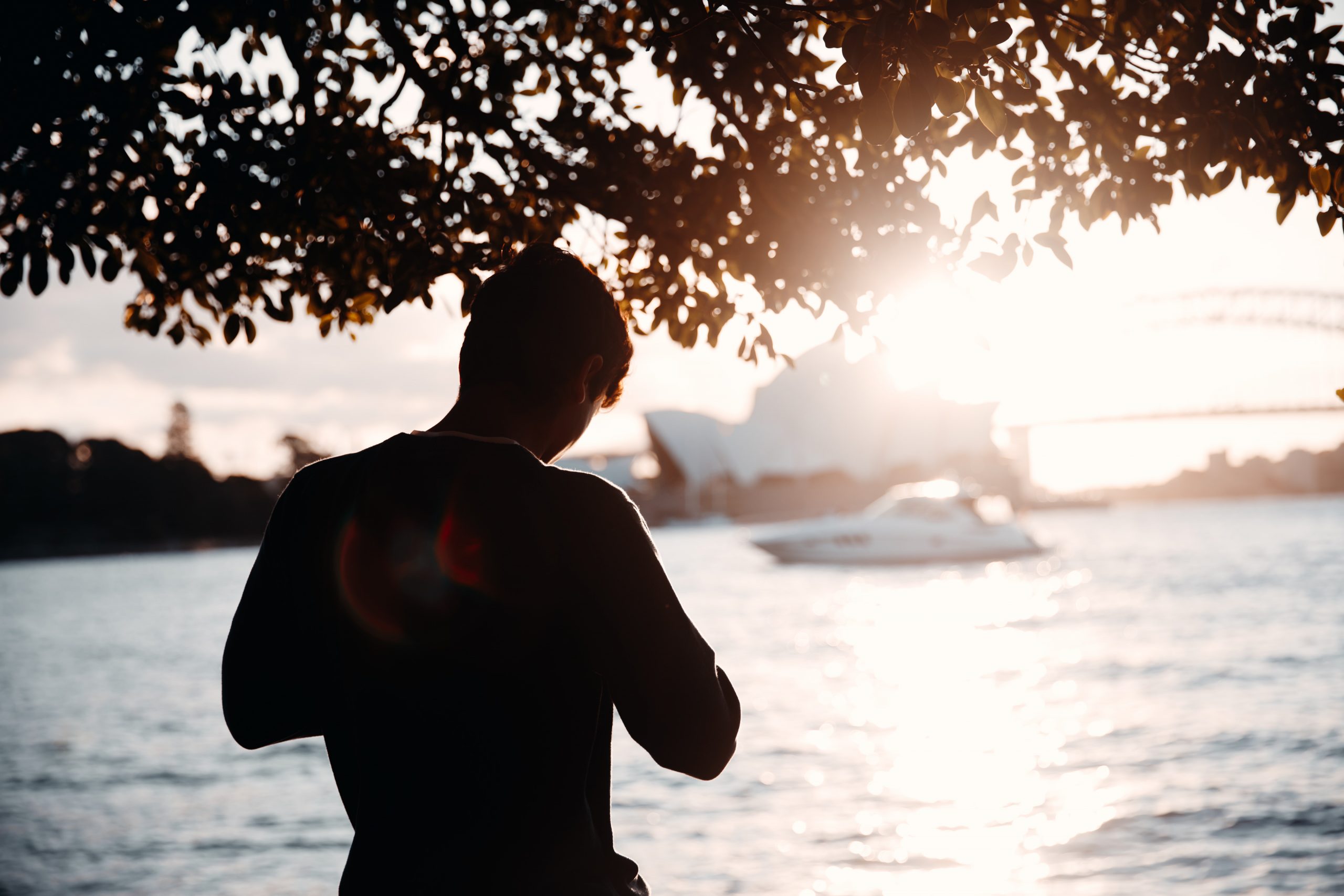 man taking a photo in front of opera house at sunset at Mrs Macquarie's Chair (The Domain)