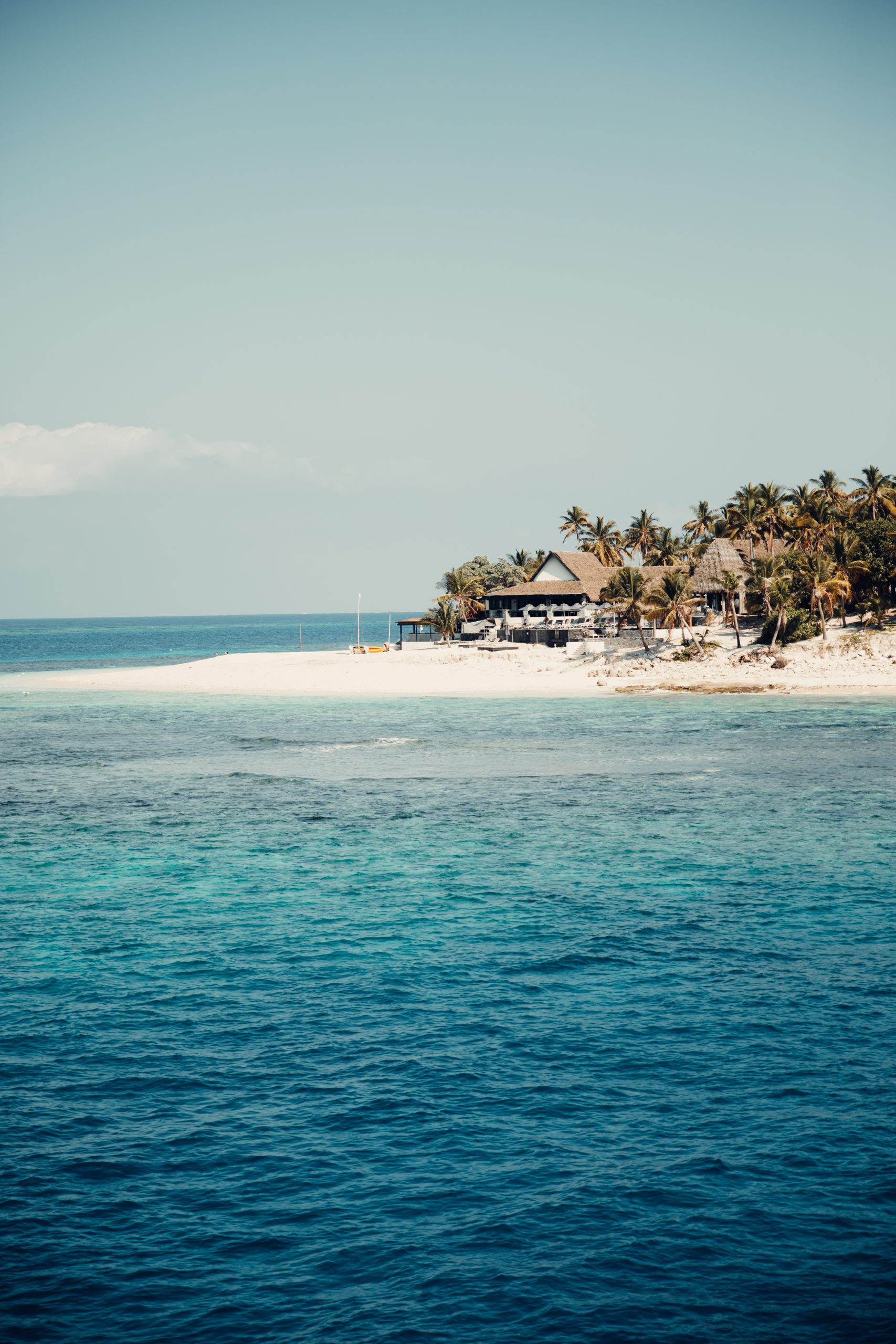 beach hut on an island in fiji overlooking blue ocean water and reef